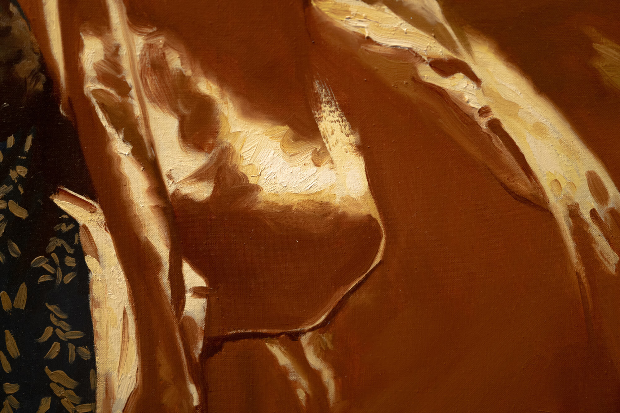 textured detail shot of a painting detail which primarily holds a gold colour with a bit of ornament showing through on the left hand side