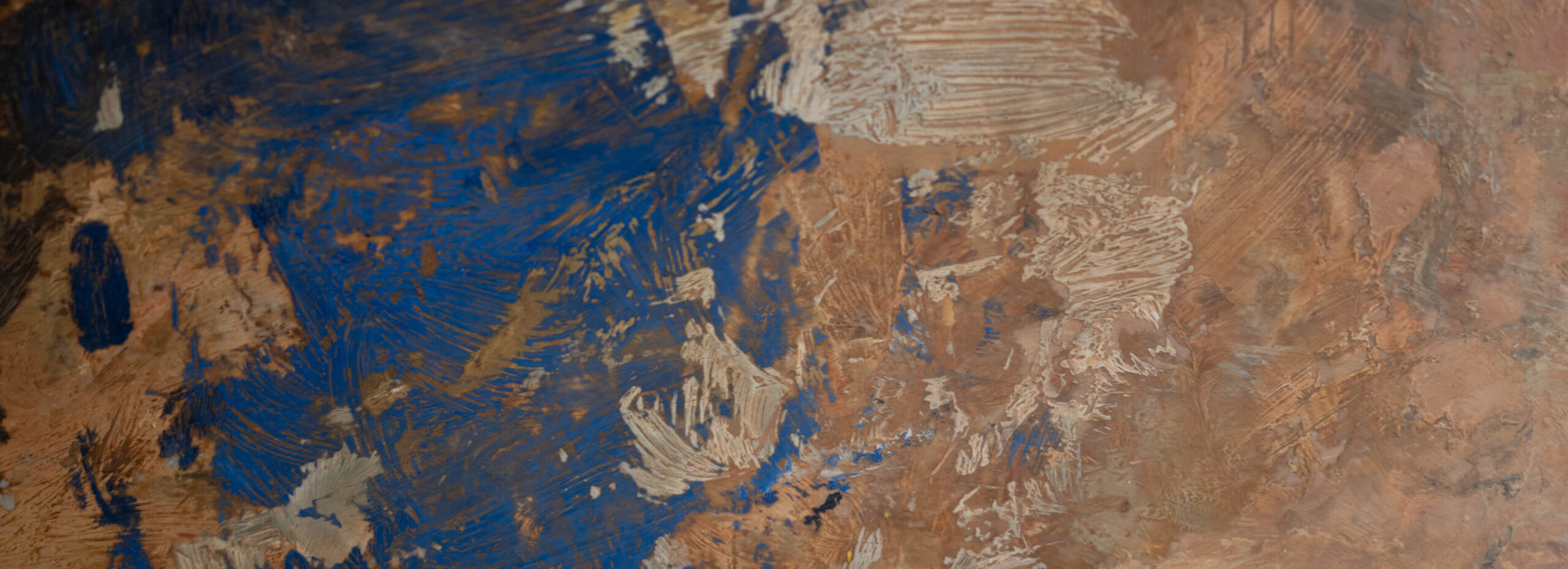a close up detail of a painting, which is abstract, there is some blue, gold and brown in it
