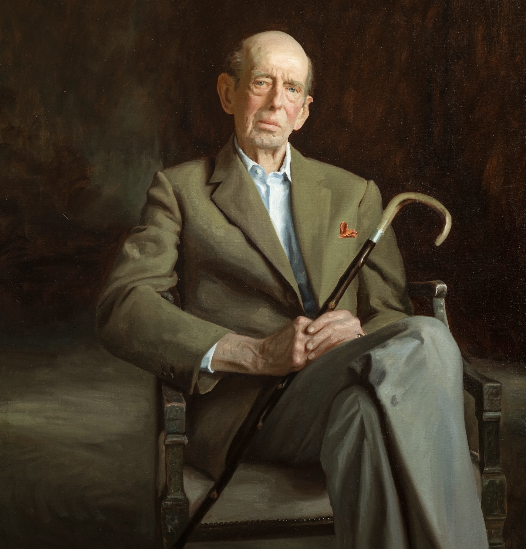 Painting of HRH Duke of Kent sitting down, wearing a khaki colour blazer, white shirt, red pocket square and dark grey trousers. He is holding a walking cane.